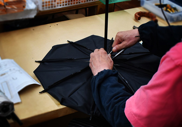 日傘を修理する男性